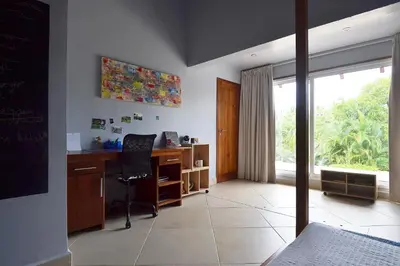a bedroom with a desk and a window and a bed at Las Terrenas Front Beach And Garden Villa with private staff in Las Terrenas