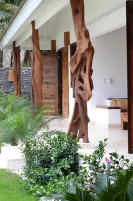 a house with wooden structures in a garden at Las Terrenas Front Beach And Garden Villa with private staff in Las Terrenas