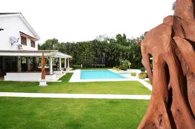 a swimming pool in a yard next to a house at Las Terrenas Front Beach And Garden Villa with private staff in Las Terrenas