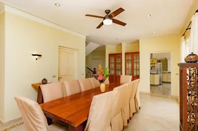 a dining room with a wooden table and a ceiling fan at Exclusive Villa at Hideaway Beach in Cabarete