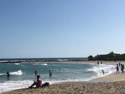 a group of people playing in the water at the beach at La Gaviota B3 in Juan Dolio