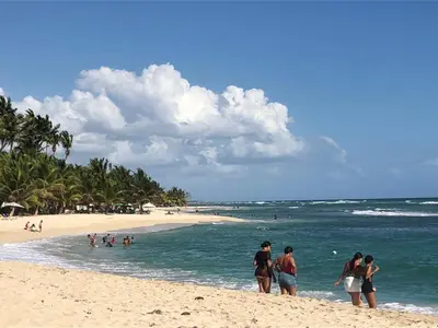 a group of people standing on a beach at La Gaviota B3 in Juan Dolio