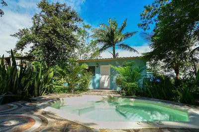 a swimming pool in front of a house at Haus unter Palmen in Jarabacoa