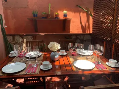 a wooden table with plates and glasses on it at Mansion Colonial Boutique Hotel Pool Jacuzzi Bar Restaurant by BTC Group Crypto in Santo Domingo