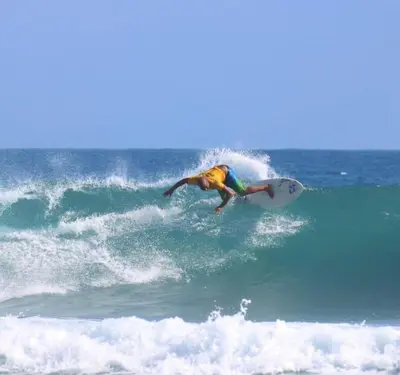 a man riding a wave on a surfboard in the ocean at The biggest swimming pool in Sosua, frente a la piscina más grande en sosua in Sosúa