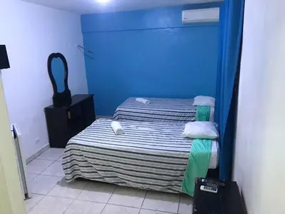 a bedroom with a bed with a blue wall at Hostal Magisterial Santo Domingo in Santo Domingo