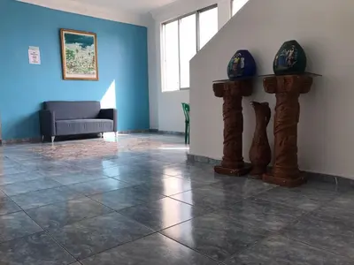 a living room with a couch and a tile floor at Hostal Magisterial Santo Domingo in Santo Domingo