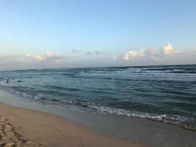 a beach with two people swimming in the ocean at La Gaviota B1 in Juan Dolio