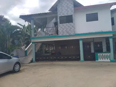 a house with a balcony with a car parked in front at Oasis de Paz 3 in Jarabacoa