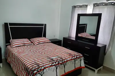 a bedroom with a bed with a mirror and a dresser at Hanly Roger's Brand new place in San Felipe de Puerto Plata