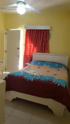 a bedroom with a bed with a red curtain at Hotel Victoriano in San Felipe de Puerto Plata