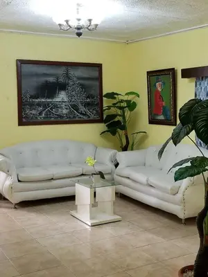 a living room with a white couch and a table at Hotel Victoriano in San Felipe de Puerto Plata