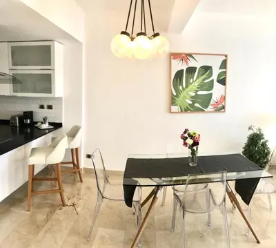 a dining room with a black table and chairs at Apartamento Acceso Directo a la piscina A-108, A-120, A-117 y B-137 in Punta Cana