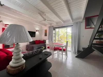 a living room with a couch and a table with a lamp at Ballenas beach C6 in Las Terrenas