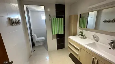a bathroom with a sink and a toilet and a mirror at Blue Boat Lindo Apartamento en Playa Juan Dolio in Juan Pedro