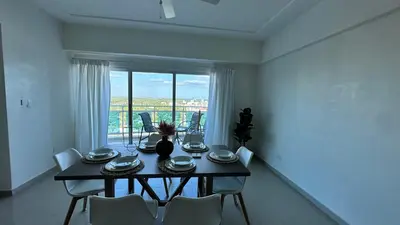 a dining room with a table and chairs and a window at Blue Boat Lindo Apartamento en Playa Juan Dolio in Juan Pedro
