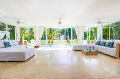 a large living room with two beds and a pool at Luxury Rentals in Punta Cana - Exclusive Waterfall Villa with Private Pool, BBQ, Maid, Golf in Punta Cana
