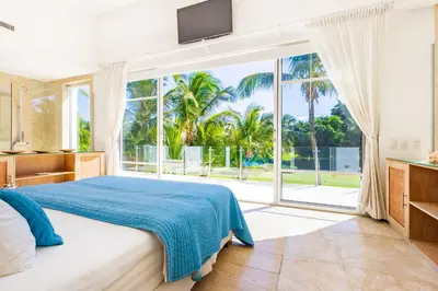a bedroom with a bed and a large window at Luxury Rentals in Punta Cana - Exclusive Waterfall Villa with Private Pool, BBQ, Maid, Golf in Punta Cana