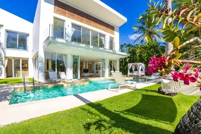 a house with a swimming pool and a yard at Luxury Rentals in Punta Cana - Exclusive Waterfall Villa with Private Pool, BBQ, Maid, Golf in Punta Cana