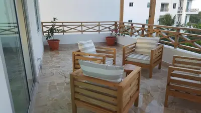 a balcony with several chairs and a table and a balcony at Saman Terrace in Las Terrenas