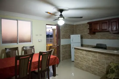 a kitchen with a table and chairs and a refrigerator at 1 Bedroom Apartment -Corales del Sur Ole Las Americas- Isabelita - Aeropuerto in La Viva