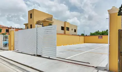 a gate in a parking lot in front of a building at 1 Bedroom Apartment -Corales del Sur Ole Las Americas- Isabelita - Aeropuerto in La Viva