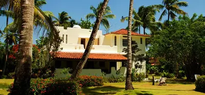 a house with palm trees in front of it at Villa directly on the beach, las Ballenas in Las Terrenas