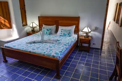 a bedroom with a large bed with blue tiled floors at Villa directly on the beach, las Ballenas in Las Terrenas
