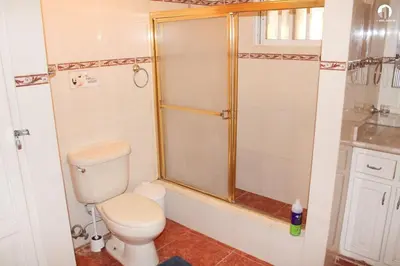a bathroom with a toilet and a shower at Villa Los Almendros - 2 private pools tennis pickle ball in Baní