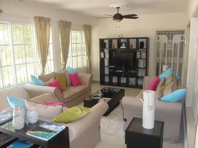 a living room with two couches and a tv at Villa Los Almendros - 2 private pools tennis pickle ball in Baní