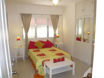 a bedroom with a bed with yellow and red pillows at Villa Los Almendros - 2 private pools tennis pickle ball in Baní