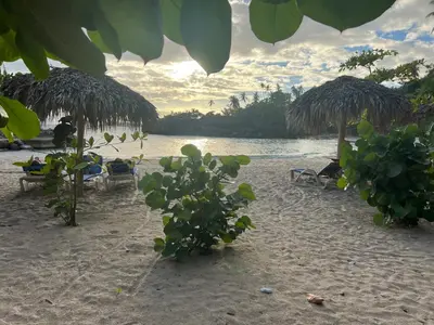 a beach with chairs and umbrellas and the water at Vista Mare Samana Amazing Views!! in Santa Bárbara de Samaná