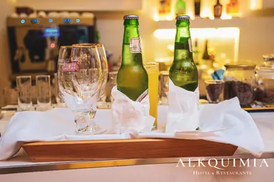 two bottles of beer sitting on a table with glasses at HOTEL ALKQUIMIA in Bayahibe