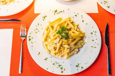 a plate of pasta with broccoli on a table at HOTEL ALKQUIMIA in Bayahibe