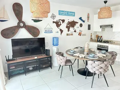 a living room with a table and a tv and a kitchen at Atmospheric apartment with a beautiful view of the swimming pool in Bayahibe