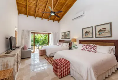 a bedroom with two beds and a flat screen tv at Stunning Villa with Private Pool and Jacuzzi in Casa de Campo in La Romana