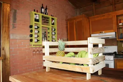 a kitchen with a bunch of wine bottles and a pineapple at Estancias Arroyazo in Constanza