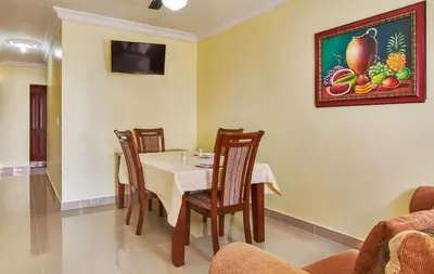 a dining room with a table and chairs and a picture on the wall at Modern Tropical 2-Bedroom Apartment with Terrace 300 Mbps Wi-Fi, power Generator in La Viva