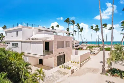 a house on the beach with palm trees at Luxury Villa in Bávaro Just on the Beach in Punta Cana