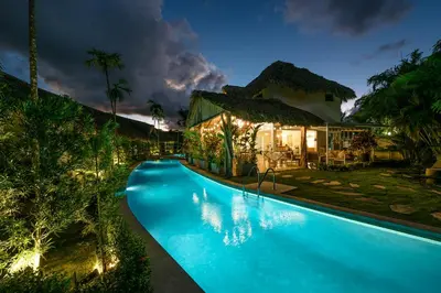 a villa with a swimming pool at night at TAKUMA BOUTIK HOTEL in Las Terrenas