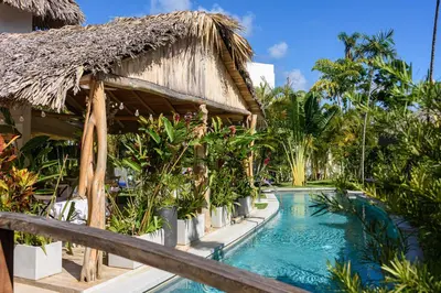a resort with a swimming pool next to a building at TAKUMA BOUTIK HOTEL in Las Terrenas