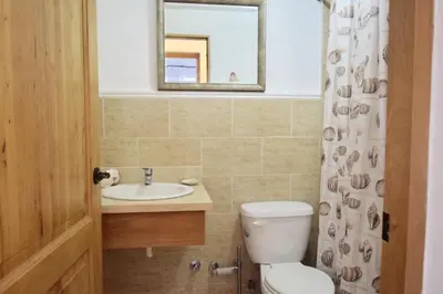 a bathroom with a toilet and a sink and a mirror at 3BR Apt @CadaquesCaribe Bayahibe in San Rafael del Yuma