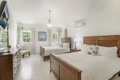 a bedroom with two beds and a couch and a table at Amazing Villa in Casa de Campo with Included in Price Maid and Waiter in La Romana