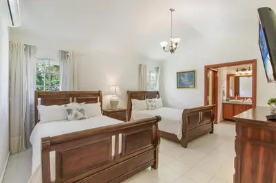 a bedroom with two beds and a mirror at Amazing Villa in Casa de Campo with Included in Price Maid and Waiter in La Romana