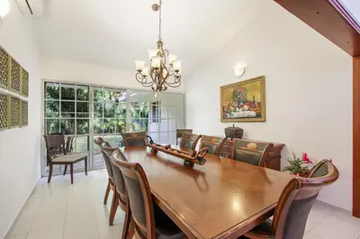 a dining room with a wooden table and chairs at Amazing Villa in Casa de Campo with Included in Price Maid and Waiter in La Romana