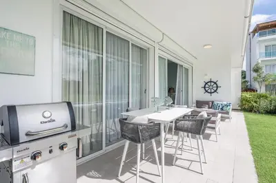 a patio with a table and chairs and a television at Playa Bonita Amazing Condo at Lake View in La Ceiba