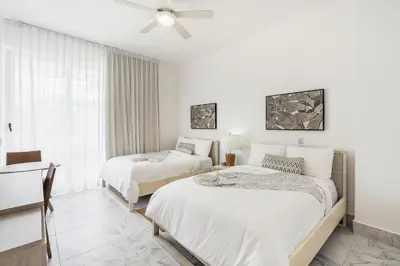 a bedroom with two beds and a ceiling fan at Playa Bonita Amazing Condo at Lake View in La Ceiba