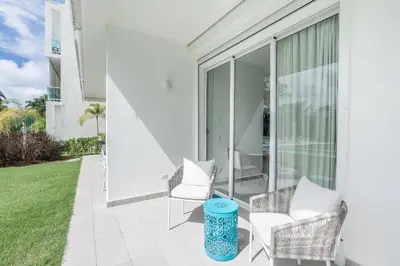 a patio with two chairs and a table at Playa Bonita Amazing Condo at Lake View in La Ceiba