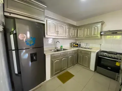 a kitchen with wooden cabinets and a stainless steel refrigerator at Santiago City Center Huge nice Apartment to stay rooftop to enjoy the city view in Santiago de los Caballeros