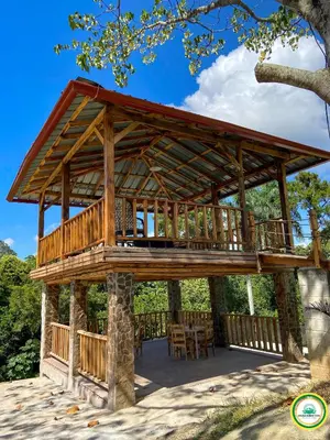 a large wooden pavilion with a table and chairs at Colina Buena vista A4 in Jarabacoa